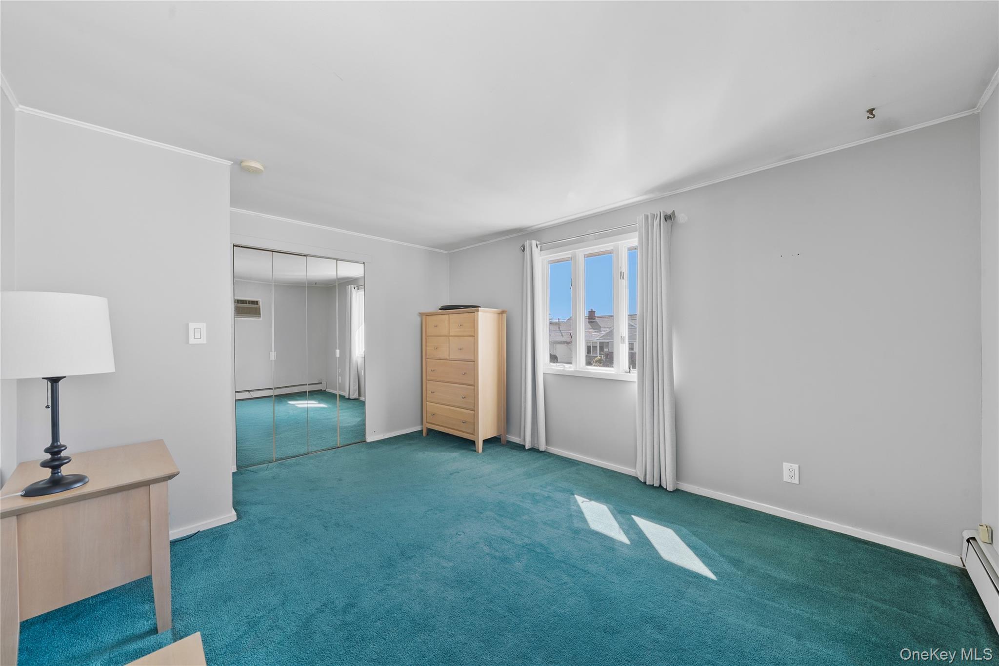 15 Hayes Road Amity Harbor, NY 11701 - Photo 15 of 46 a view of an empty room with a window and wooden floor