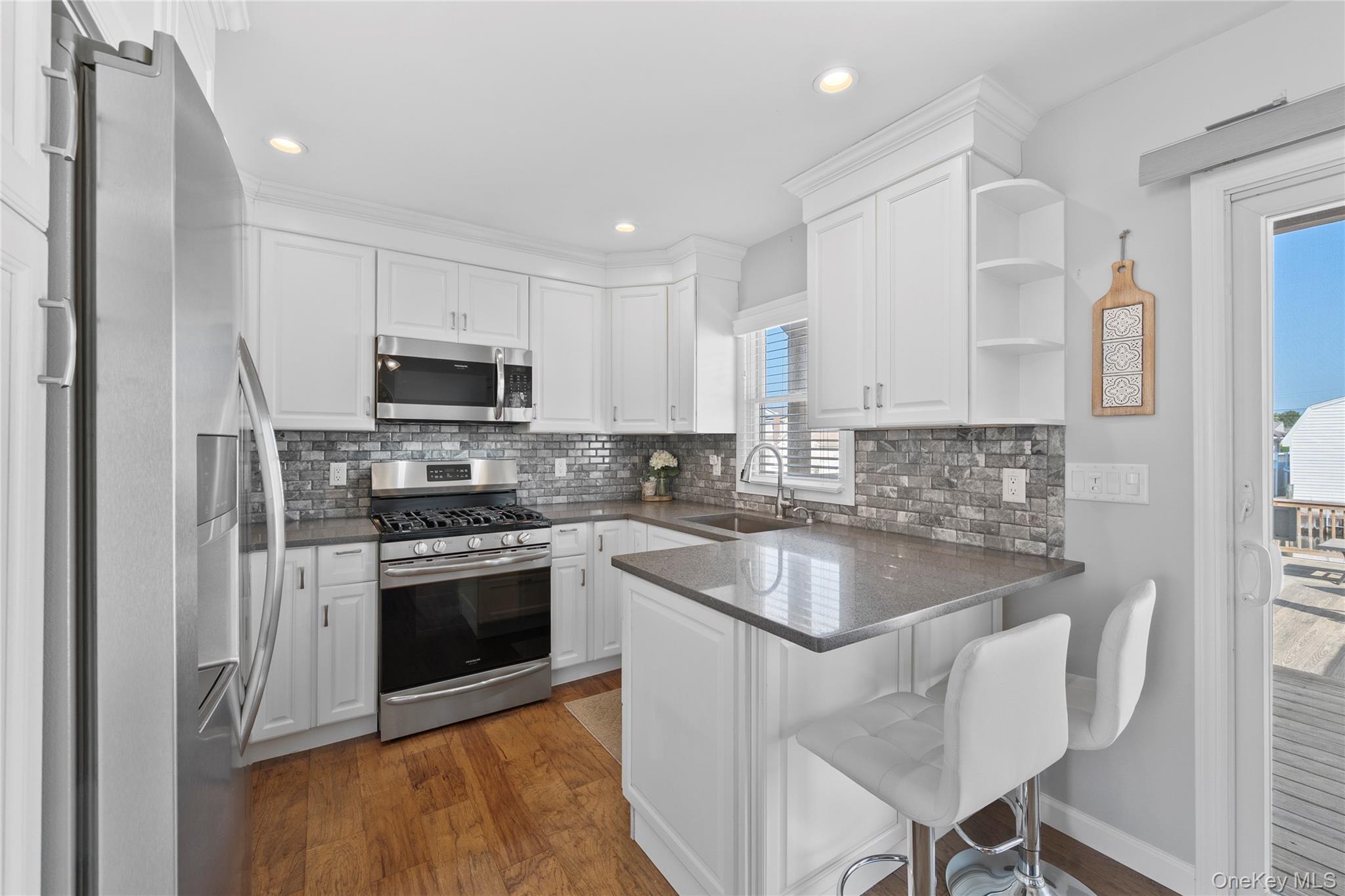 15 Hayes Road Amity Harbor, NY 11701 - Photo 8 of 46 a kitchen with kitchen island granite countertop a sink stove and microwave