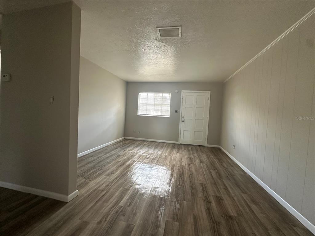 1806 East 138th Avenue Tampa, FL 33613 - Photo 5 of 19 an empty room with wooden floor and windows