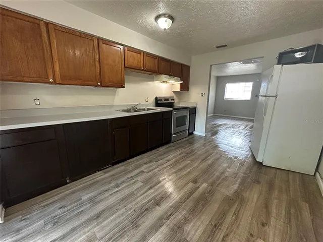 a kitchen with granite countertop wooden cabinets a sink and dishwasher