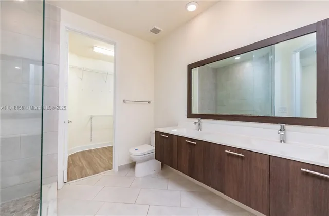 a bathroom with a double vanity sink mirror and bathtub