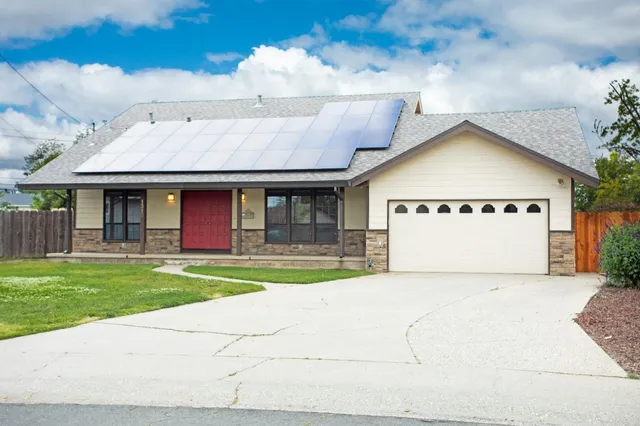a view of a house with a yard and a garage