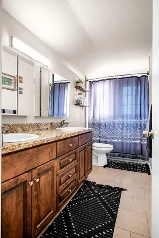 a kitchen with granite countertop a refrigerator and a stove top oven