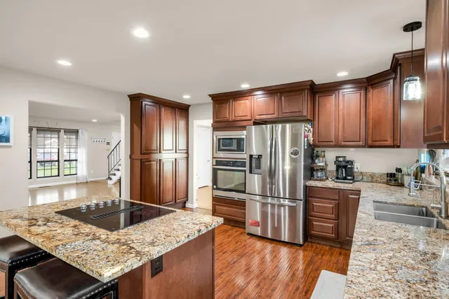 a view of a hallway with wooden floor and a bathroom