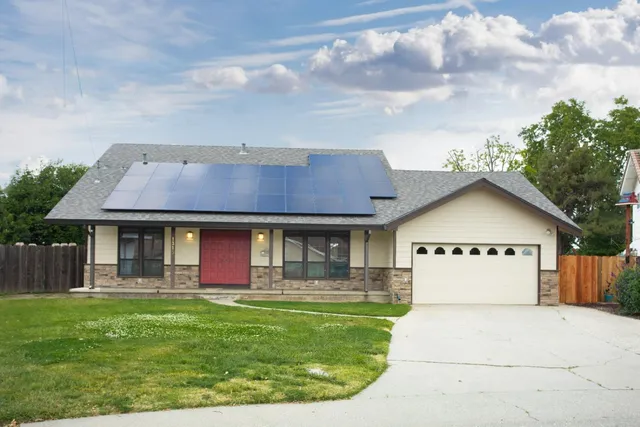 a front view of a house with a garden and yard
