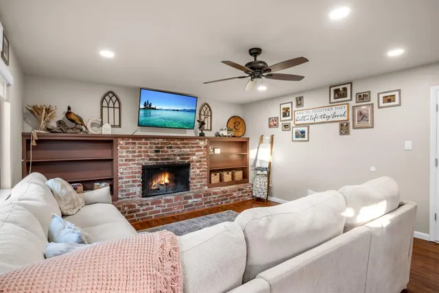 a living room with furniture a fireplace and a flat screen tv