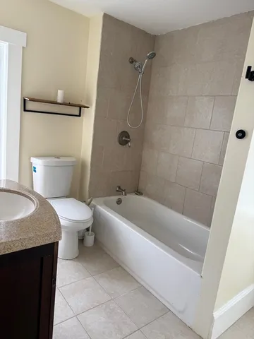 a spacious bathroom with a granite countertop sink toilet and bathtub
