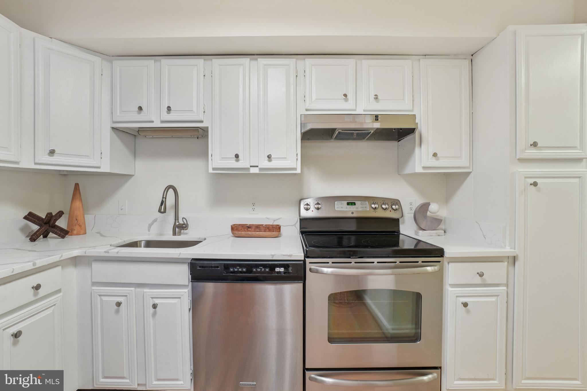 2141 P Street Northwest, Unit 709 Washington, DC 20037 - Photo 14 of 23 a kitchen with granite countertop white cabinets and white appliances