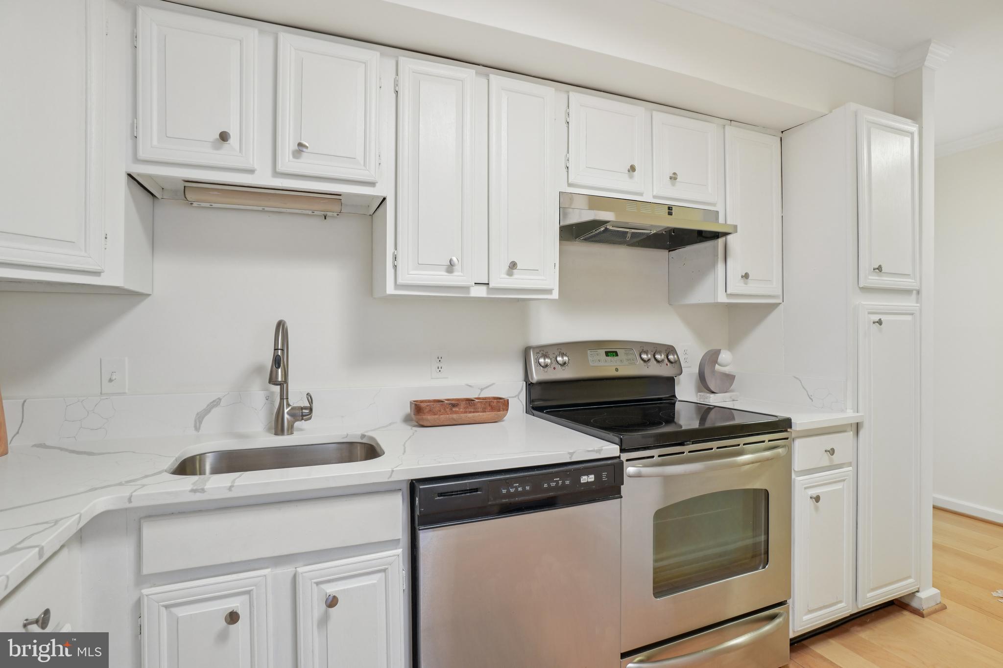 2141 P Street Northwest, Unit 709 Washington, DC 20037 - Photo 15 of 23 a kitchen with granite countertop white cabinets and white appliances