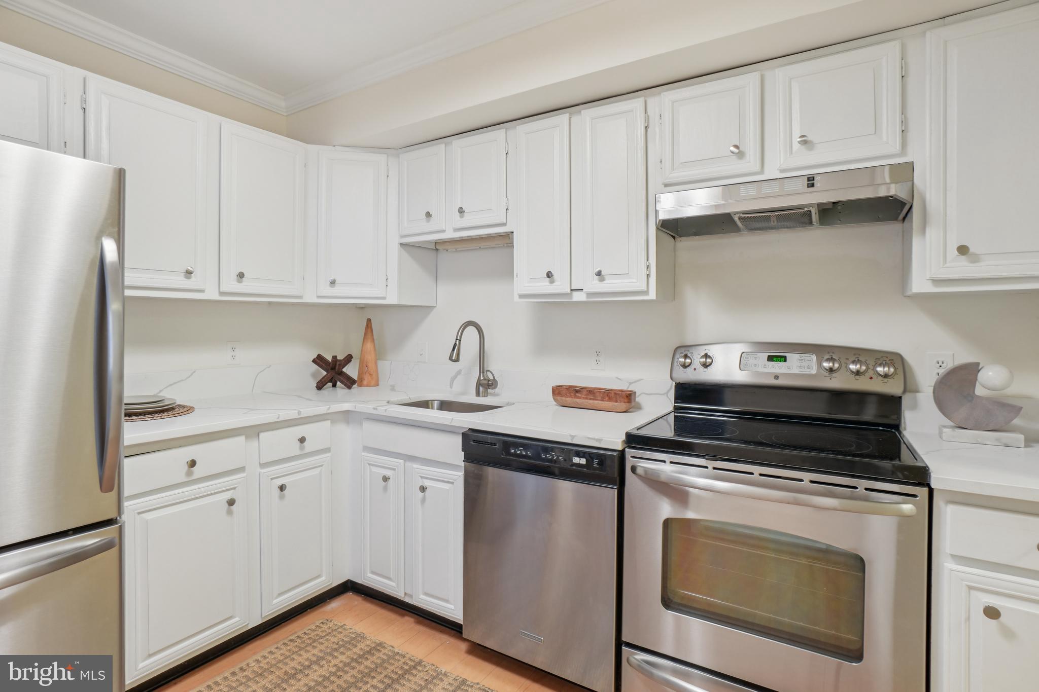 2141 P Street Northwest, Unit 709 Washington, DC 20037 - Photo 3 of 23 a kitchen with granite countertop white cabinets and white appliances