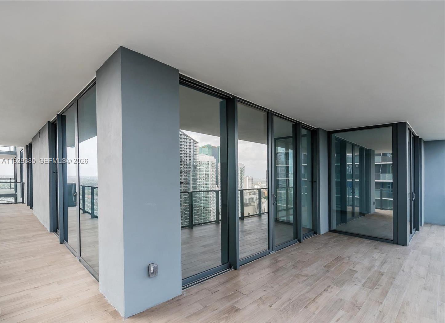 88 Southwest 7th Street, Unit 2501 Miami, FL 33130 - Photo 4 of 38 wooden floor in an empty room with entrance and windows