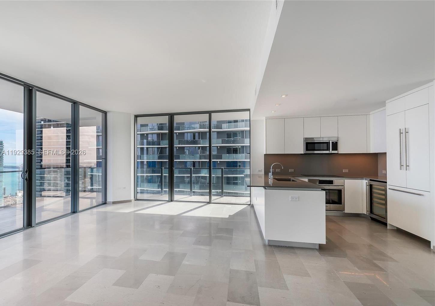 88 Southwest 7th Street, Unit 2501 Miami, FL 33130 - Photo 9 of 38 a kitchen with stainless steel appliances a large counter top a stove a chimney a sink and cabinets