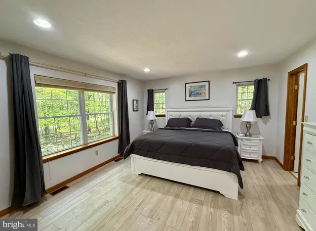 a bed sitting in a spacious bedroom next to a window