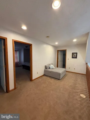 a living room with furniture and a hallway