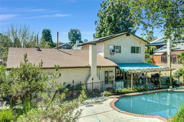 a view of a house with pool yard and sitting area