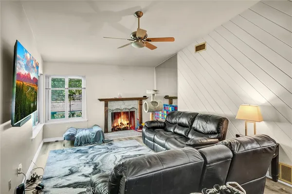 a living room with furniture a flat screen tv and a fireplace
