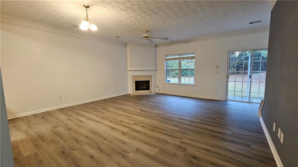 1501 Parc Main Street Lawrenceville, GA 30046 - Photo 4 of 16 an empty room with wooden floor fireplace and windows