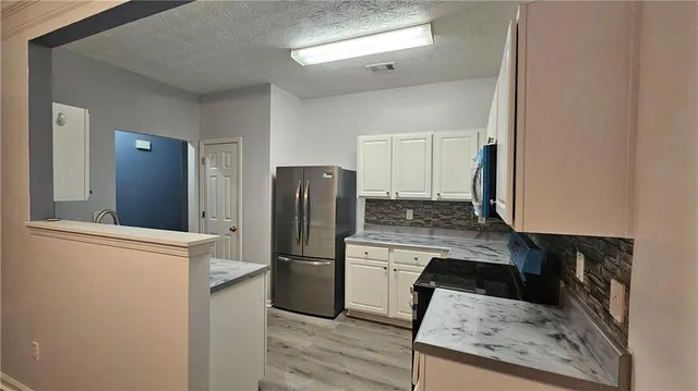 a kitchen with a refrigerator and a stove top oven