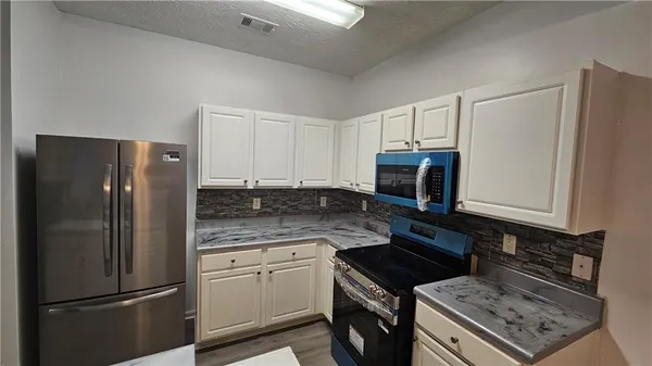 a kitchen with a refrigerator stove and microwave