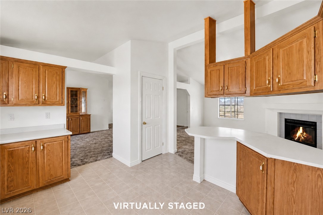 4361 Maple Road Pahrump, NV 89048 - Photo 7 of 35 A well-lit kitchen with ample cabinetry and a cozy fireplace.