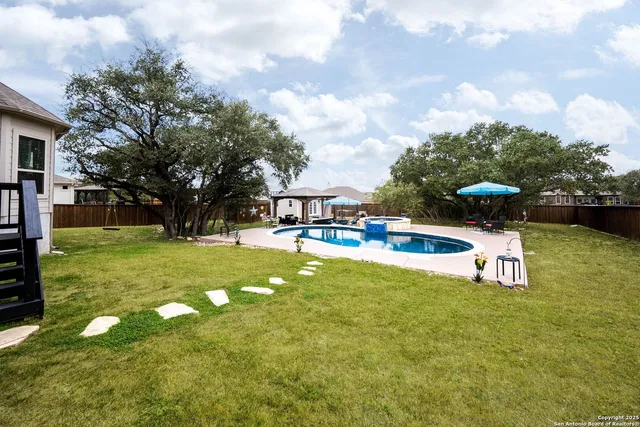 a view of backyard with potted plants and wooden fence