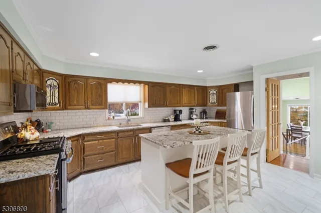 a kitchen with stainless steel appliances kitchen island granite countertop a sink and cabinets