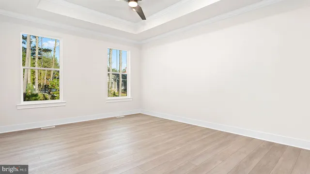 an empty room with a window and wooden floor