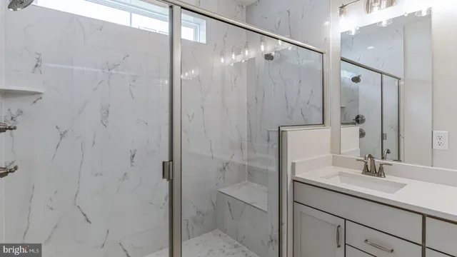 a bathroom with a shower sink and mirror