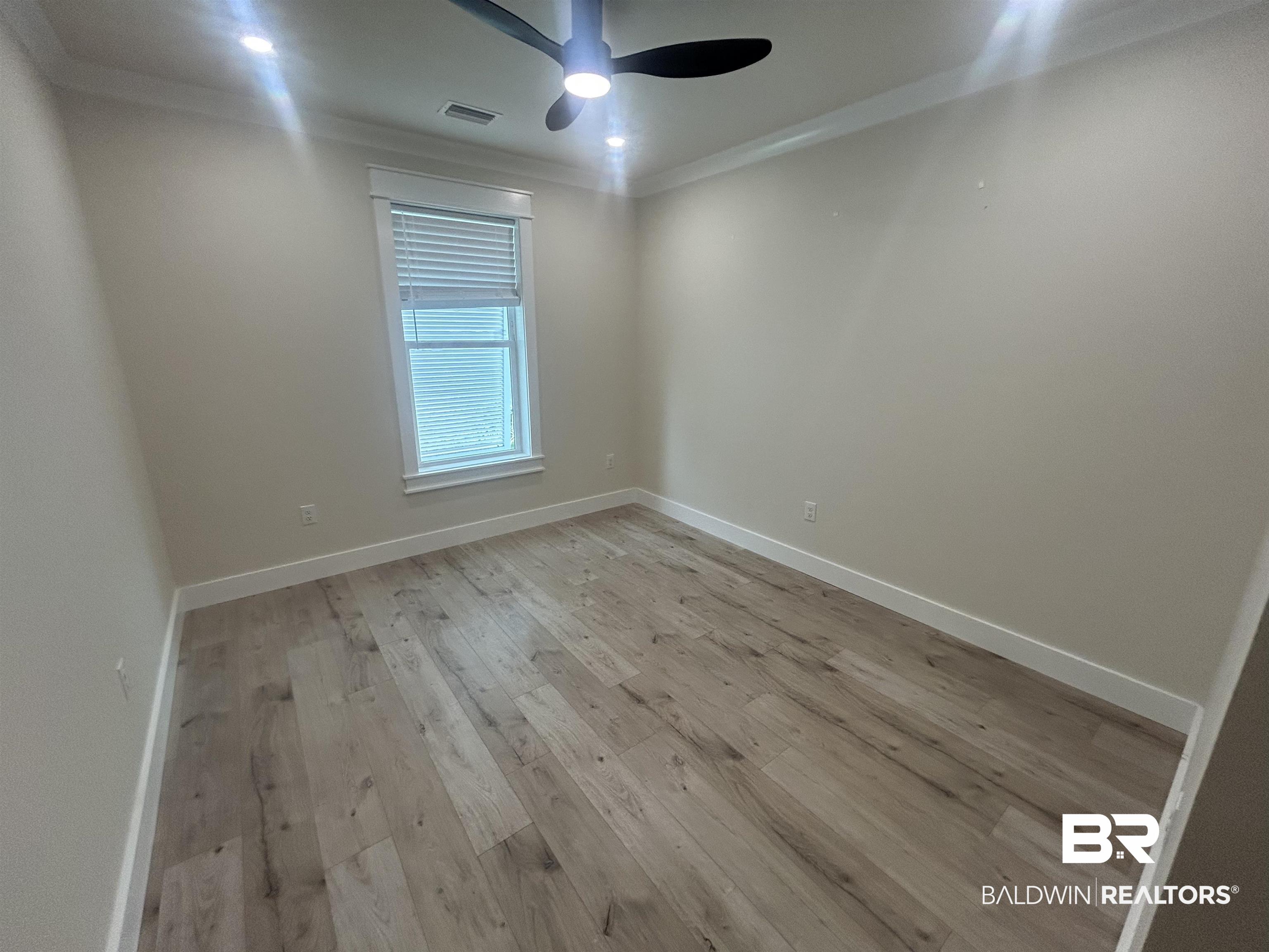 5122 Pine Road Orange Beach, AL 36561 - Photo 14 of 24 Unfurnished room featuring light wood-style floors, ornamental molding, and ceiling fan