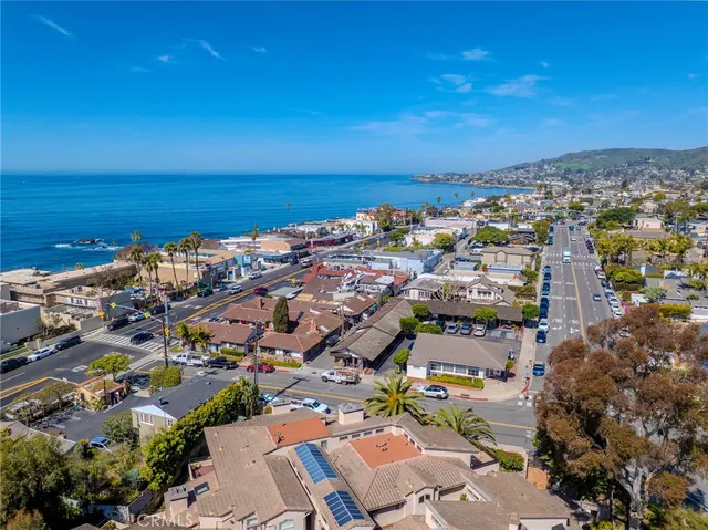 an aerial view of a city with lots of residential buildings and ocean view