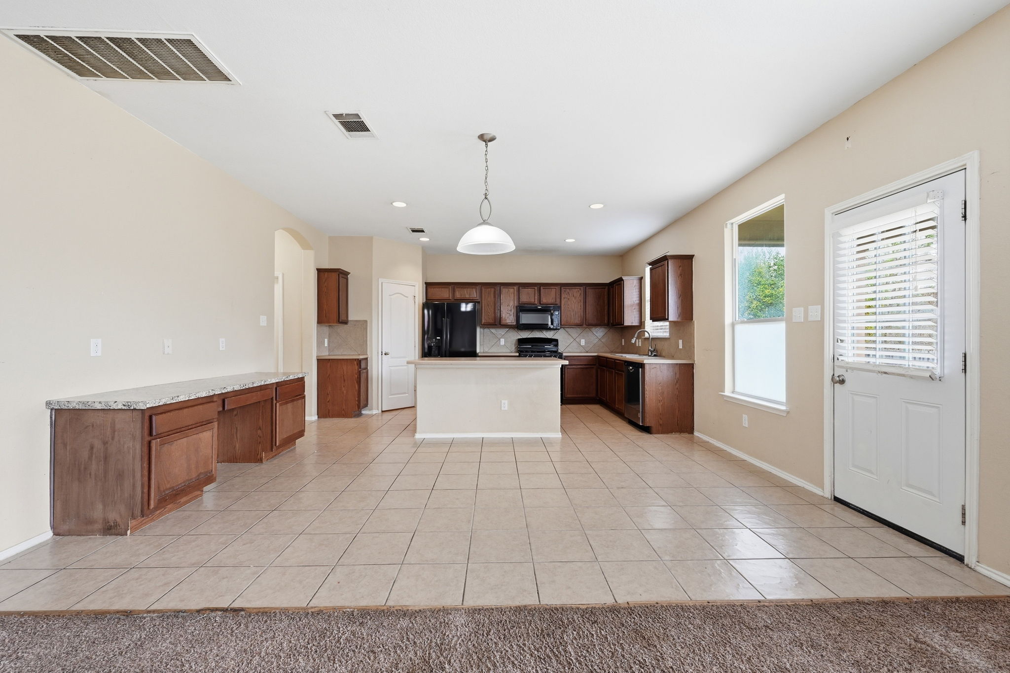 12621 Waynespur Lane Elgin, TX 78621 - Photo 12 of 34 a large kitchen with stainless steel appliances granite countertop a stove and cabinets