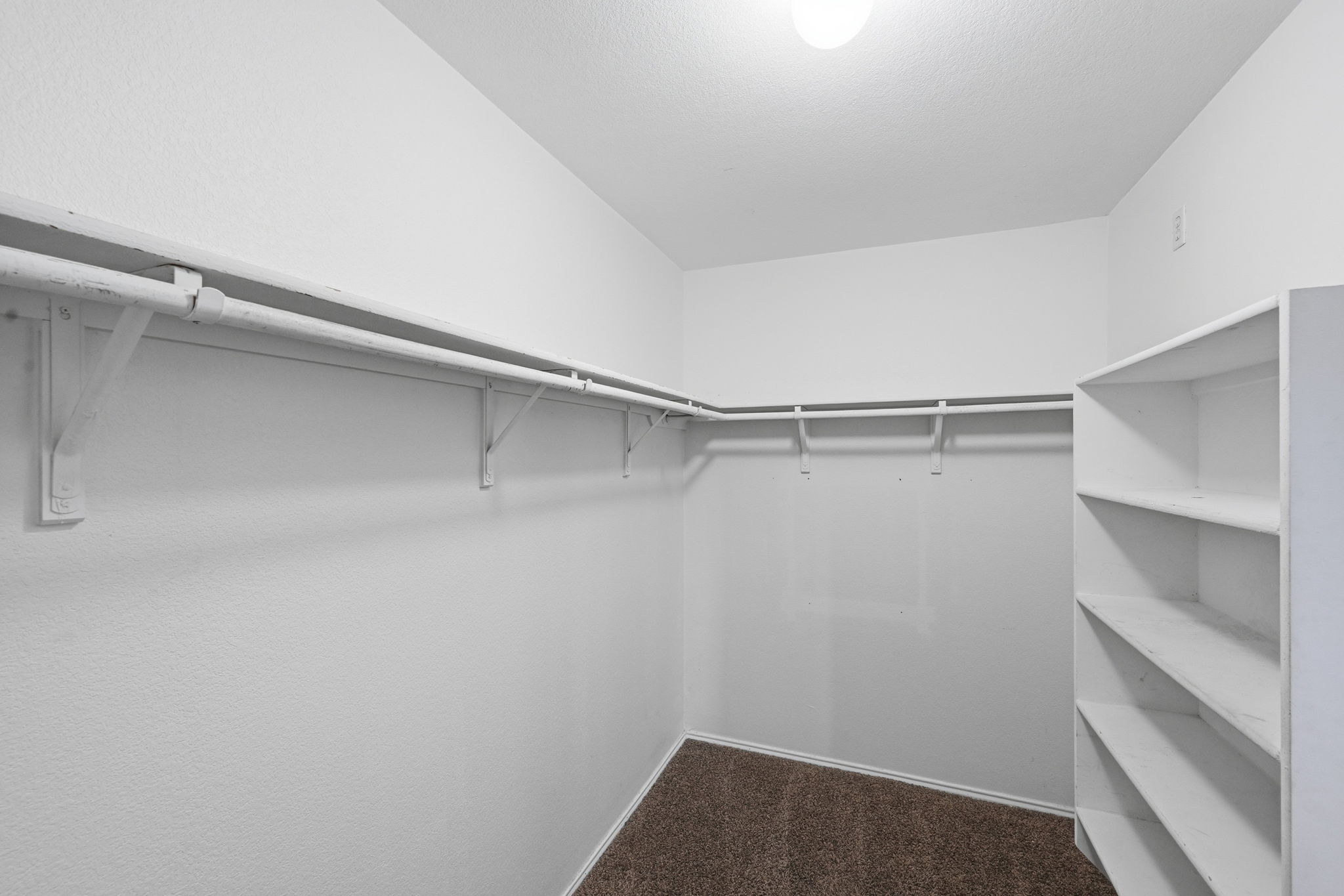 12621 Waynespur Lane Elgin, TX 78621 - Photo 23 of 34 a view of walk in closet with empty racks