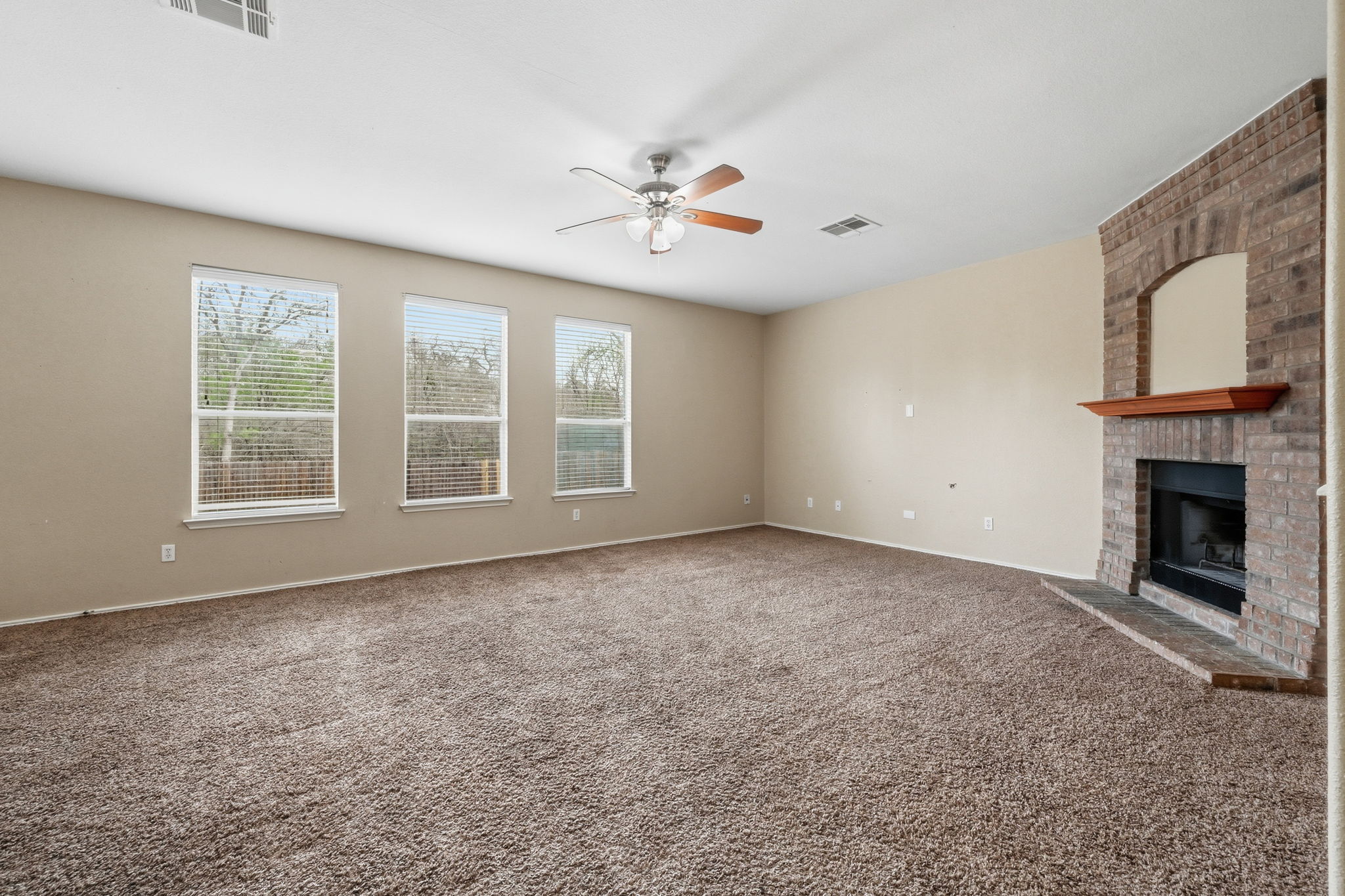 12621 Waynespur Lane Elgin, TX 78621 - Photo 7 of 34 an empty room with windows and fireplace
