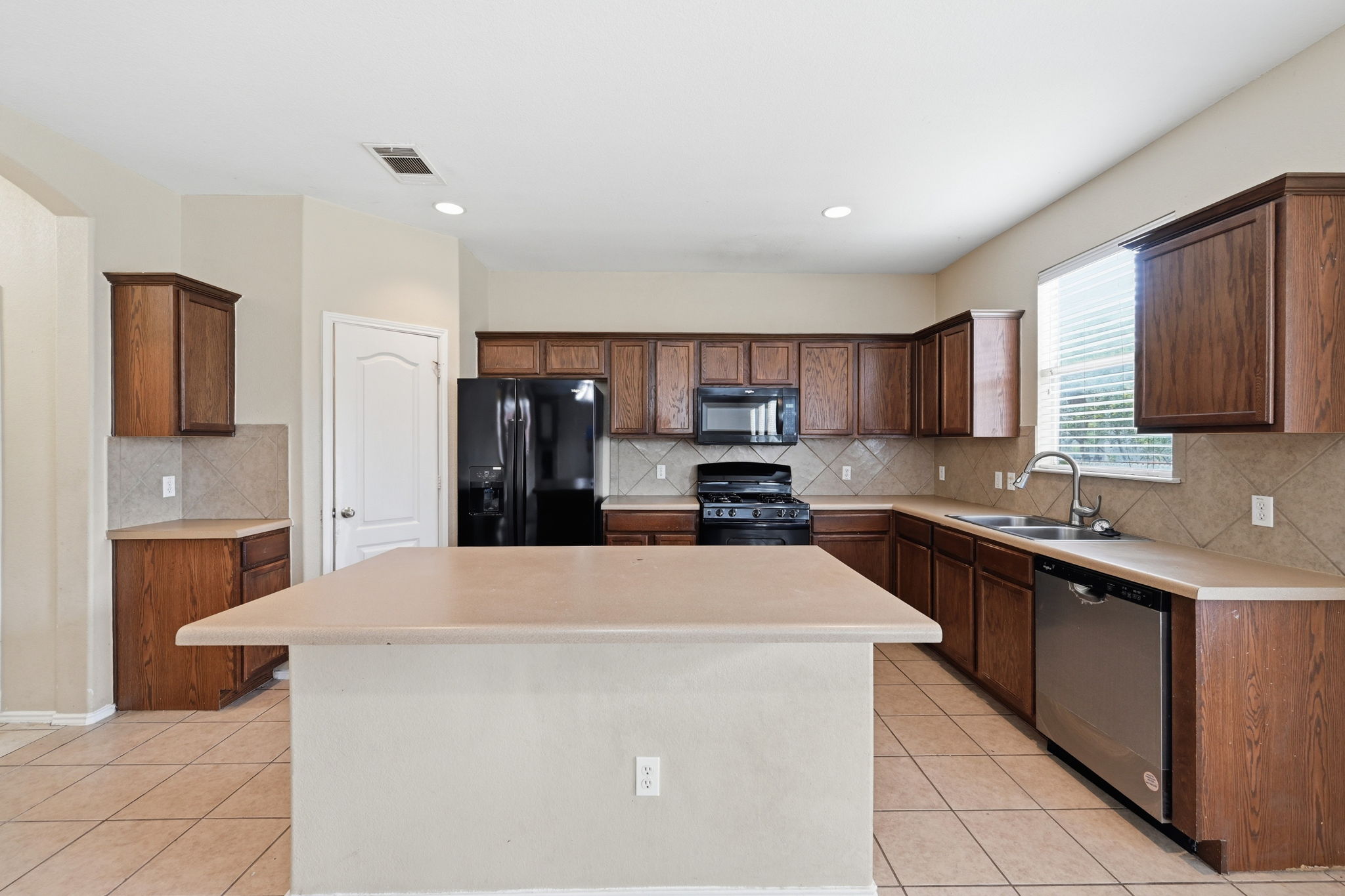 12621 Waynespur Lane Elgin, TX 78621 - Photo 9 of 34 a kitchen with stainless steel appliances a sink stove and refrigerator