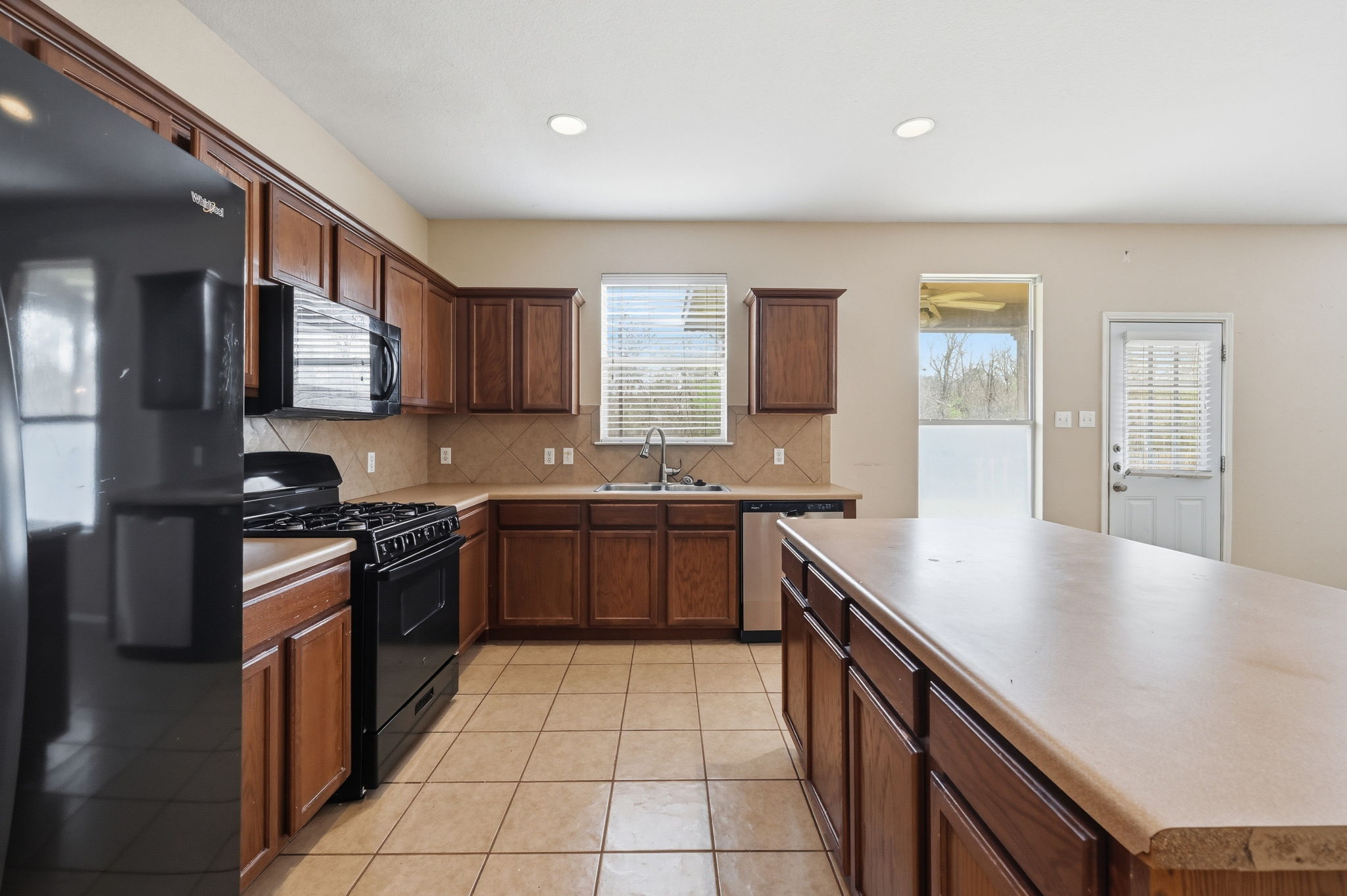 12621 Waynespur Lane Elgin, TX 78621 - Photo 10 of 34 a kitchen with stainless steel appliances granite countertop a sink stove and cabinets