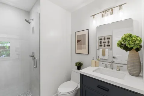 a bathroom with a sink vanity mirror and toilet