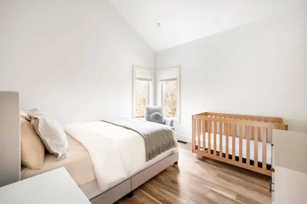 a bedroom with a bed and wooden floor