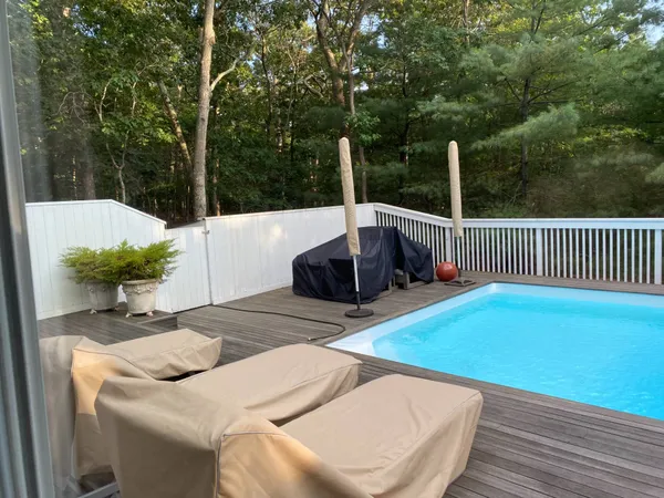 a view of backyard with swimming pool and outdoor seating