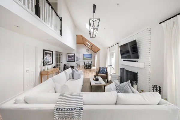 a living room with furniture a fireplace and a flat screen tv