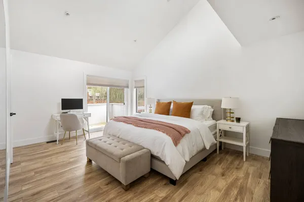 a bedroom with a bed wooden floor and lamp