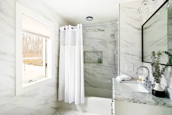 a bathroom with a tub shower and sink