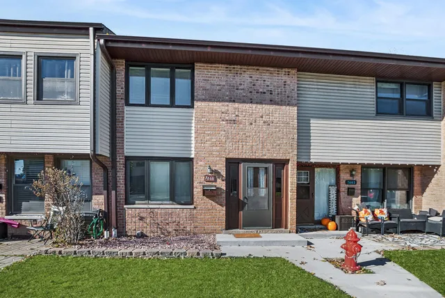 a view of a house with many windows and plants