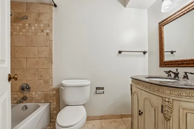 a bathroom with a granite countertop toilet a sink and a bathtub