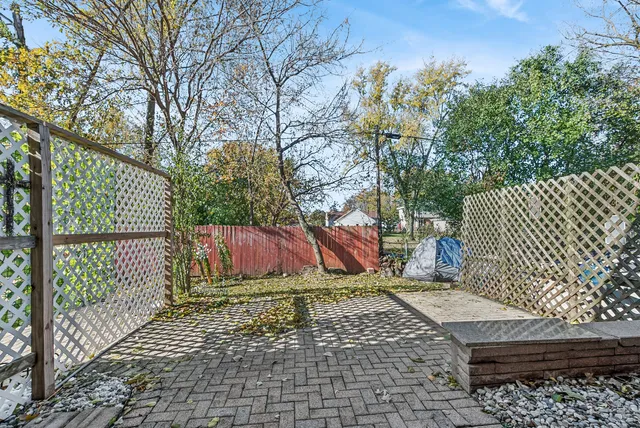 a view of backyard with wooden fence and trees