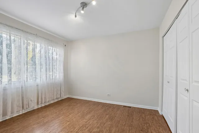a view of an empty room with wooden floor
