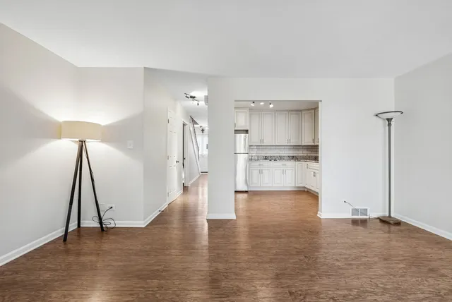 a view of empty room with wooden floor and window
