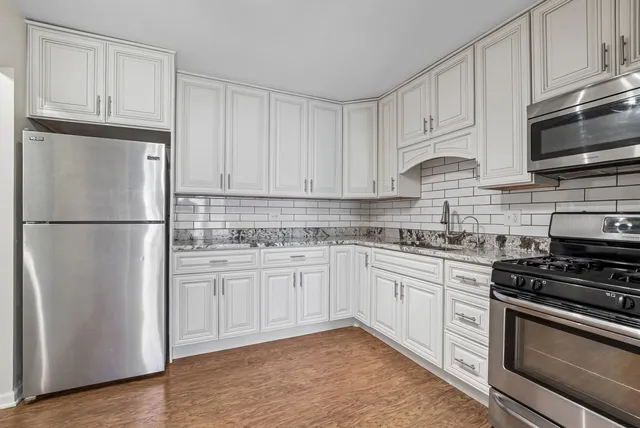 a kitchen with stainless steel appliances granite countertop a refrigerator stove a sink and a microwave