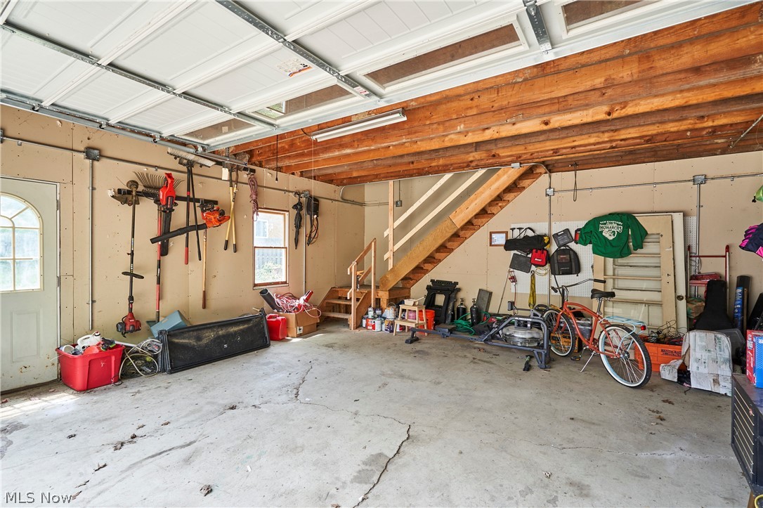 780 Bates Road Rocky River, OH 44116 - Photo 31 of 35 Spacious garage featuring exposed wood beam ceiling, concrete flooring, and a visible staircase providing access to an upper level