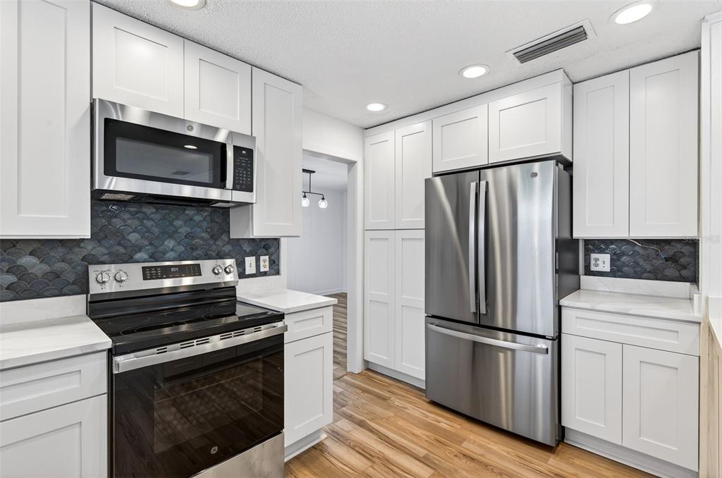 1520 South Keene Road Clearwater, FL 33756 - Photo 17 of 60 a kitchen with stainless steel appliances a refrigerator stove and microwave