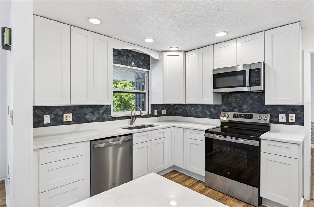 1520 South Keene Road Clearwater, FL 33756 - Photo 19 of 60 a kitchen with a sink stove and microwave